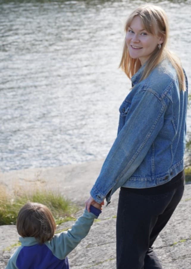 Bild på Vendela som håller sin systers barn i handen. 
