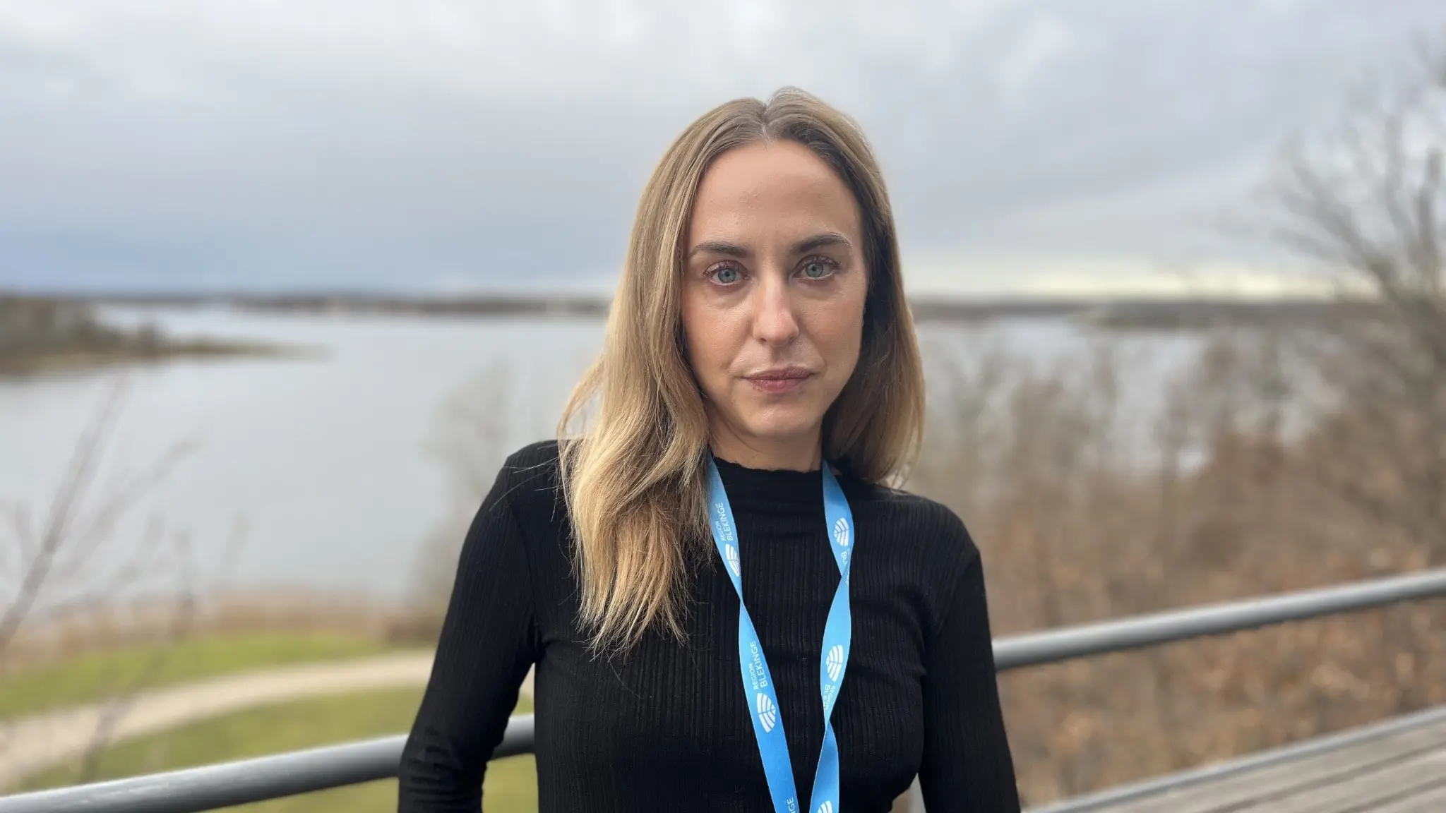 Vaccinationssamordnare Charlotte Ros står utomhus med havet i bakgrunden, iklädd svart tröja. 