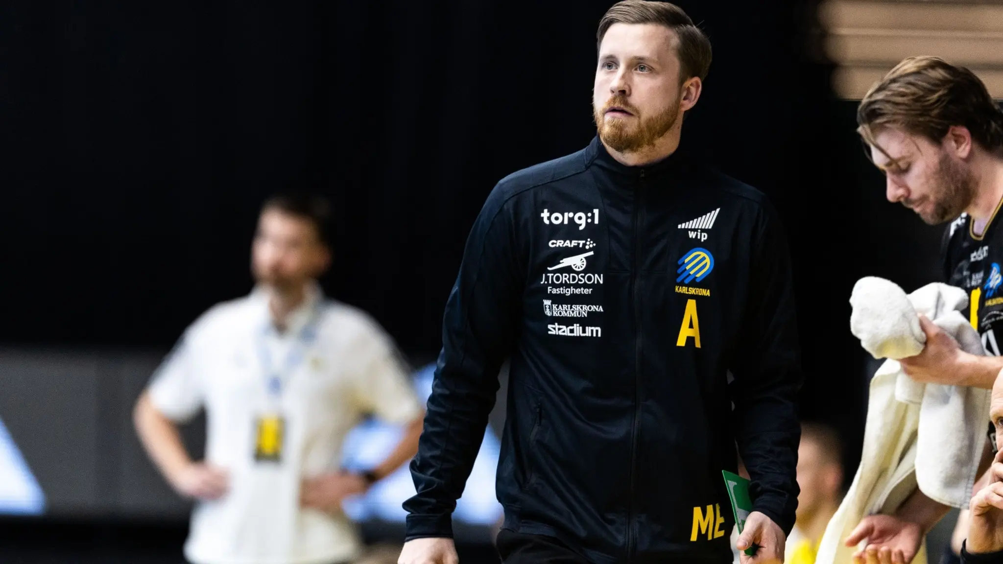 Mathias Ekstrand, klädd i träningskläder, ses i halvbild intill en spelarbänk.