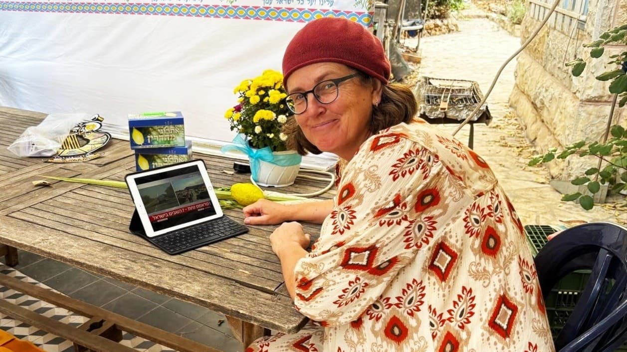 Sara Yarden sitter vid ett bord utomhus och arbetar på en surfplatta. Bordet är dekorerat med blommor och citroner, och omgivningen består av en trädgårdsmiljö. Sara om släppta gisslan: ”Hoppas på en nya dag”