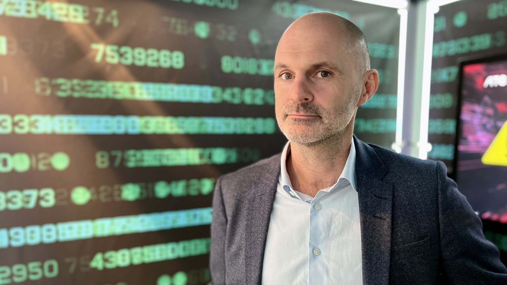 Carl-Johan Ekelund, säkerhetsexpert på IT-företaget Atea, står framför skärmar med siffror. 