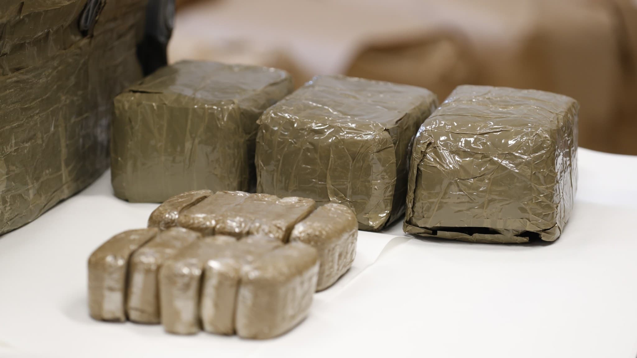 Bild på beslagtagna paket med cannabis inslagna i plast, uppställda på en vit yta. Beslaget gjordes i samband med en operation på Østlandet där 600–700 kilo narkotika togs i beslag.