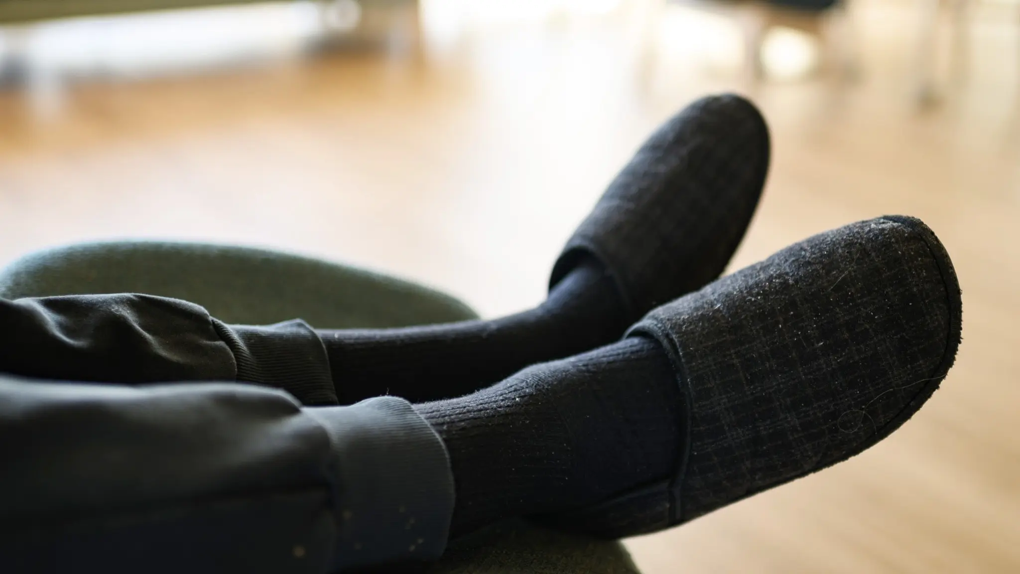 Tofflor på person som sitter och vilar på ett omsorgsboende för äldre
