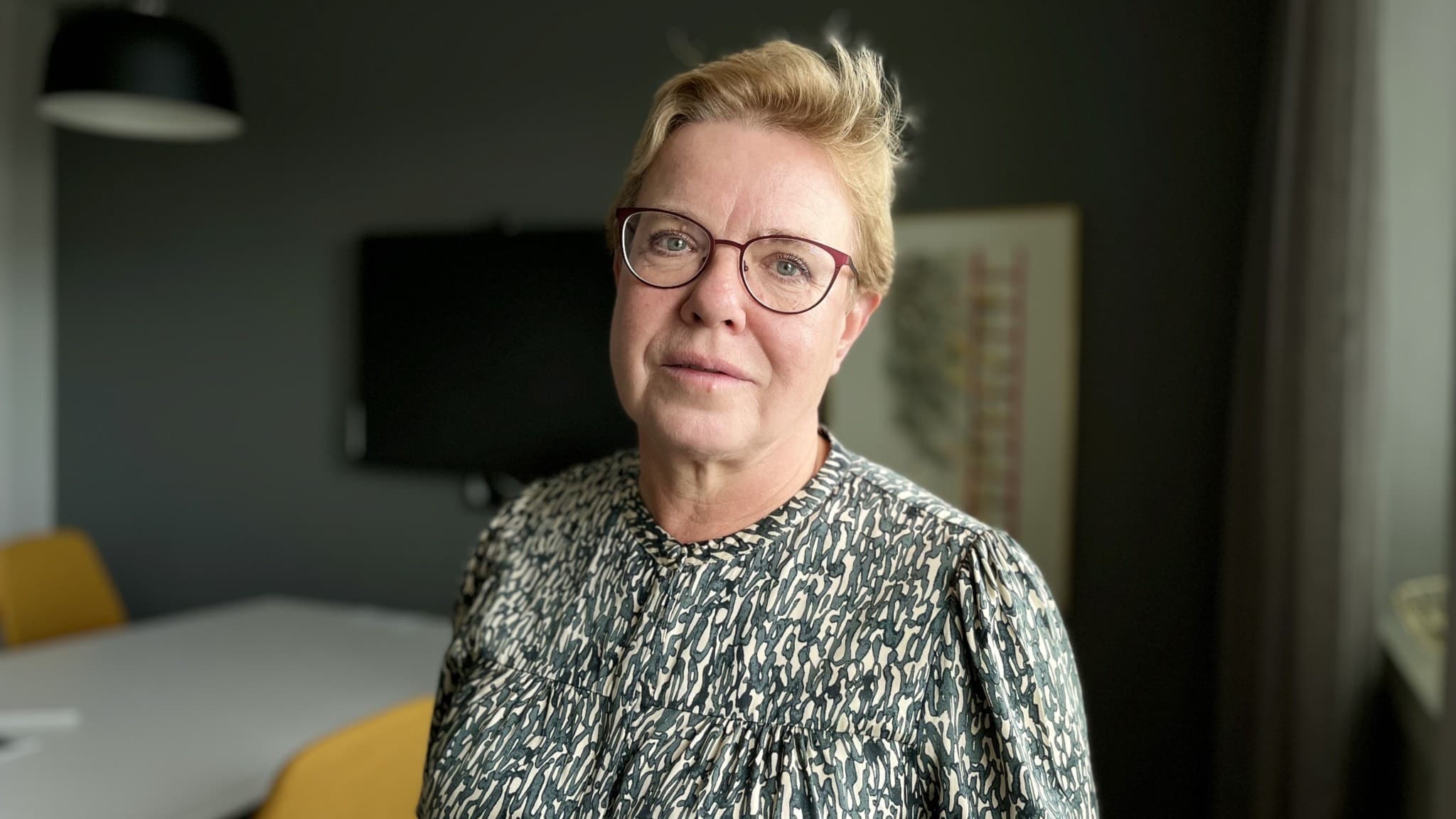 Ann-Charlott Gustafsson är socialnämndens ordförande. Hon är engagerade i ett lokalt borgerligt parti som kallas Uddevallapartiet, och som profilerat sig som ett parti med förankring i lokalt näringsliv. Ann-Charlott är en kvinna med kort hår, något äldre, glasögon med distinkt svart ram. Hon bär en svartvit-melerad tröja. 