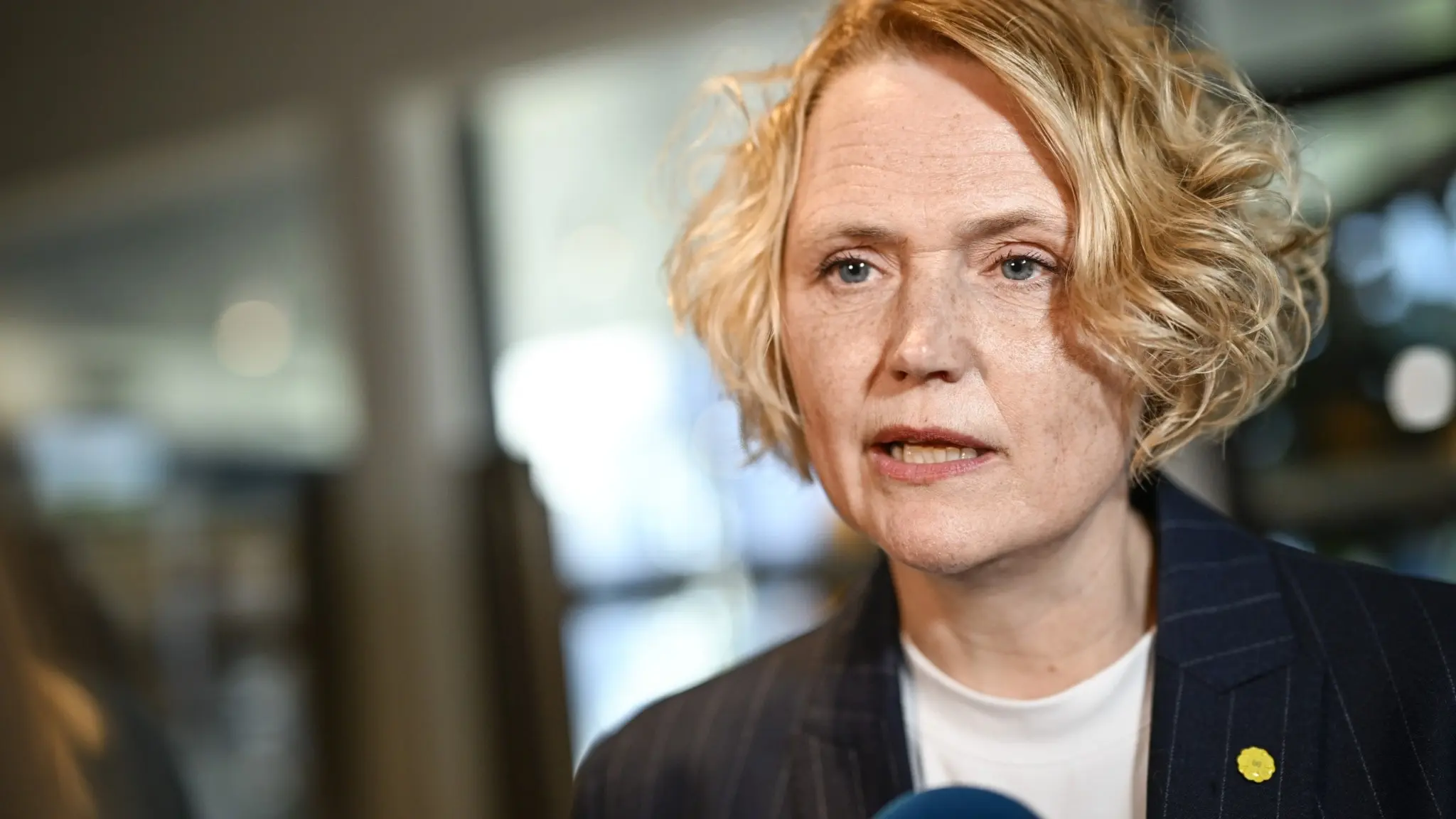 Centerpartiets Anna-Karin Hatt ses i närbild iklädd mörk kavaj med en grön blomsterpin på bröstet, inför partiledardebatten i SVT:s Agenda i Stockholm.