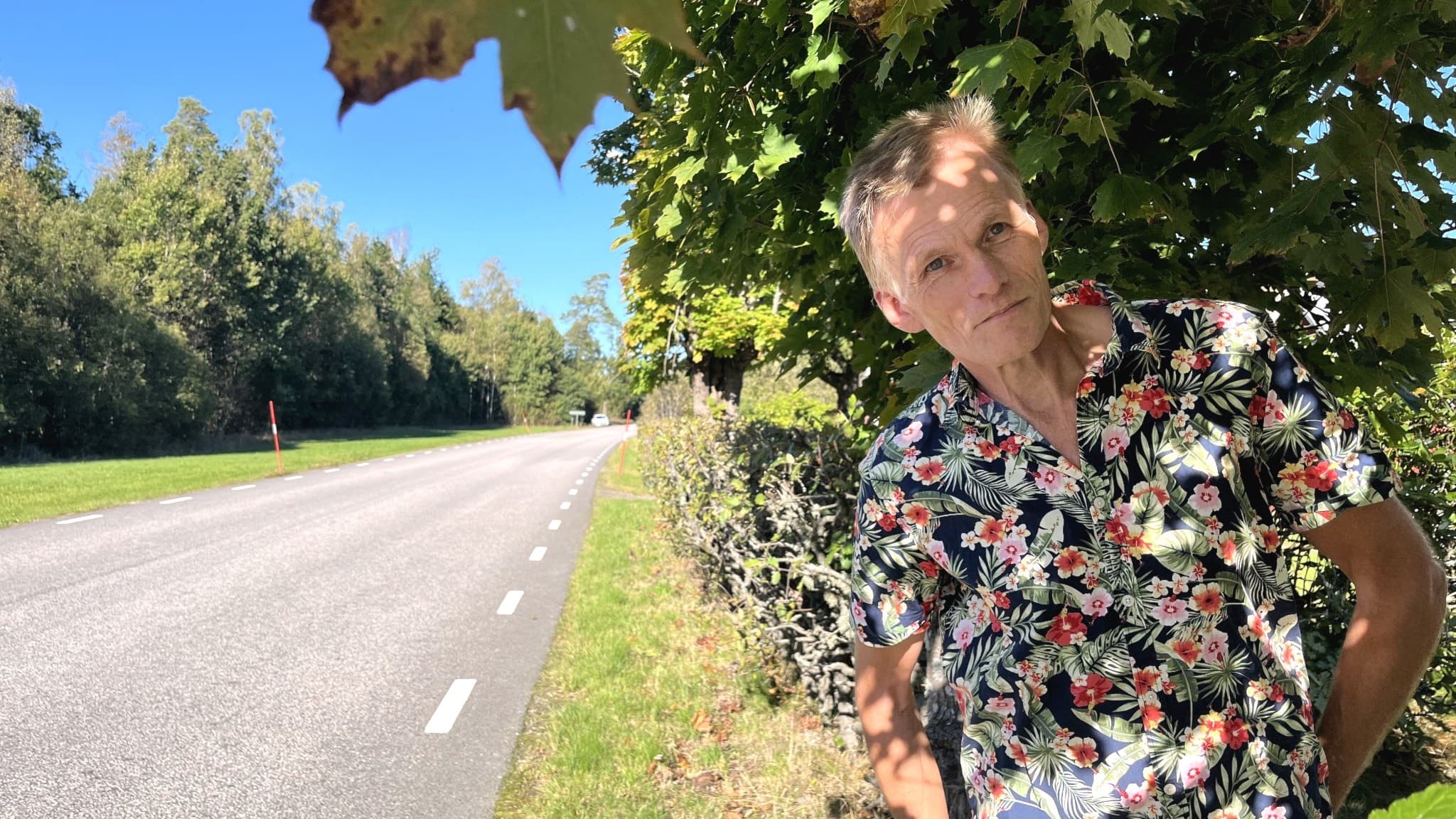 Man står vid en väg där han krockade med en älg i fjol.