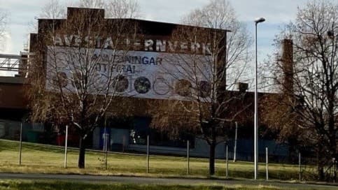 Brun byggnad där det står Avesta jernverk. 