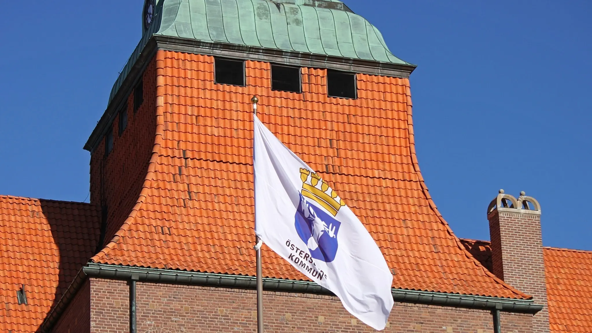 Östersunds kommuns flagga vajar i vinden framför Rådhuset.