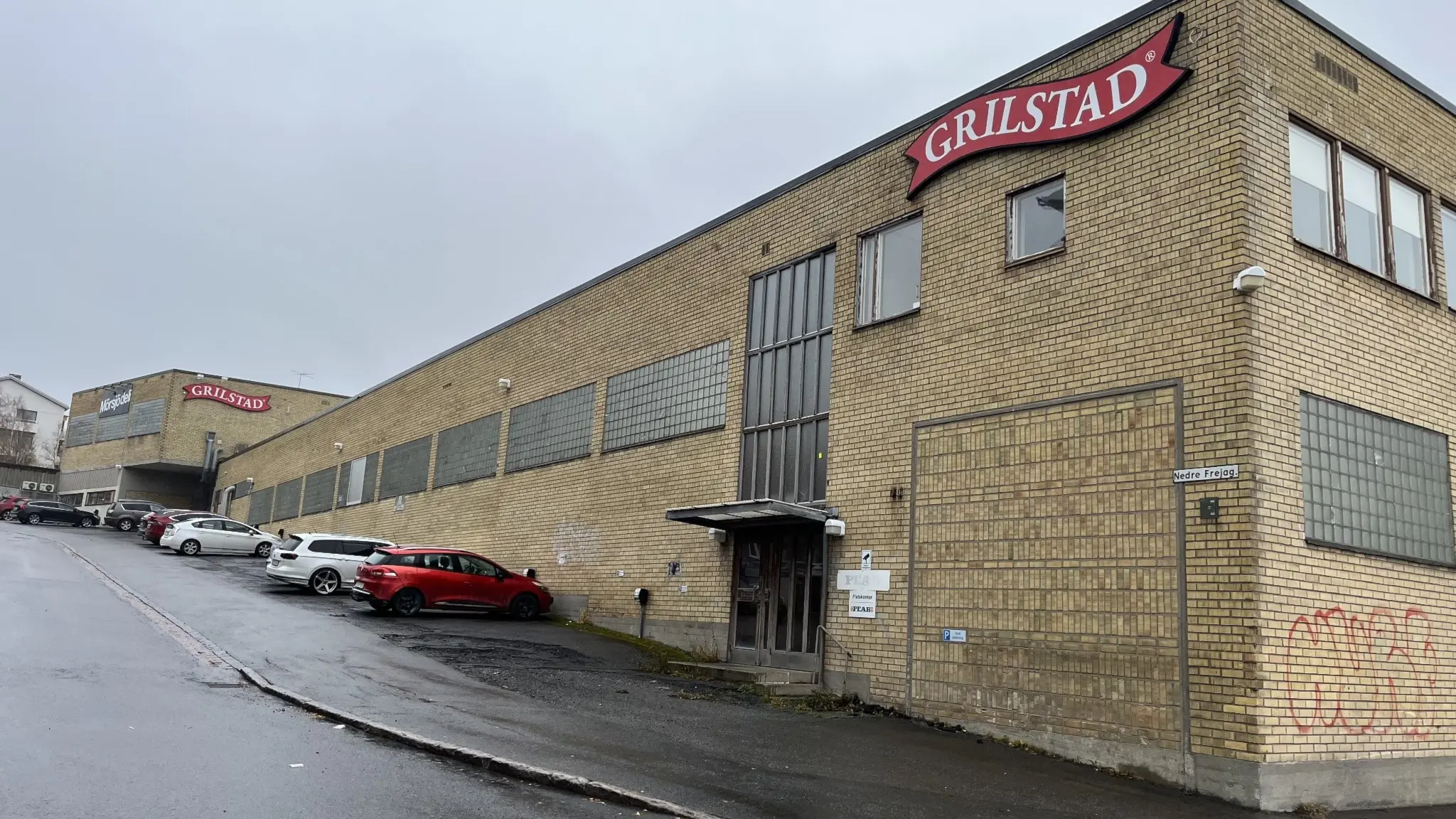 En gul tegelbyggnad med en röd skylt märkt "GRILSTAD" högst upp.
