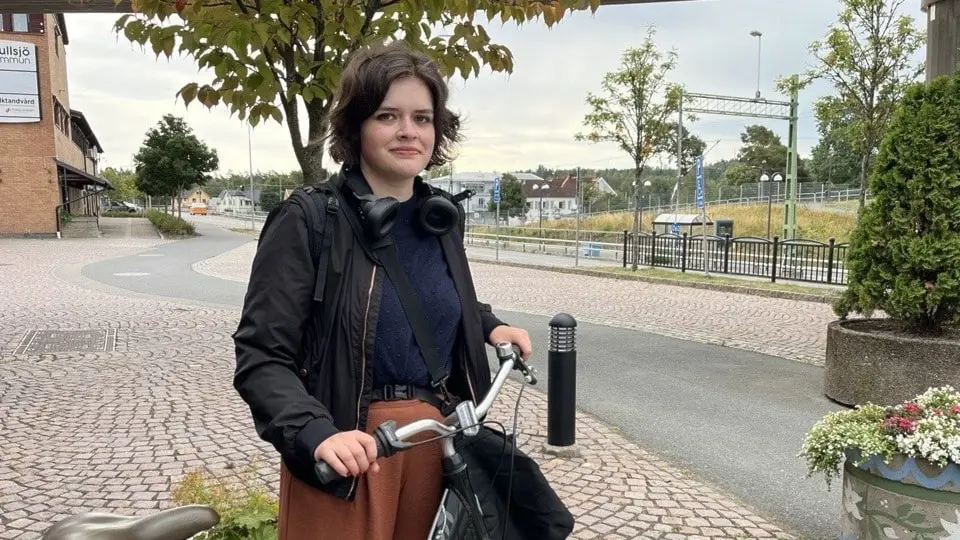 Emelie Höglund står med sin cykel vid gågata.