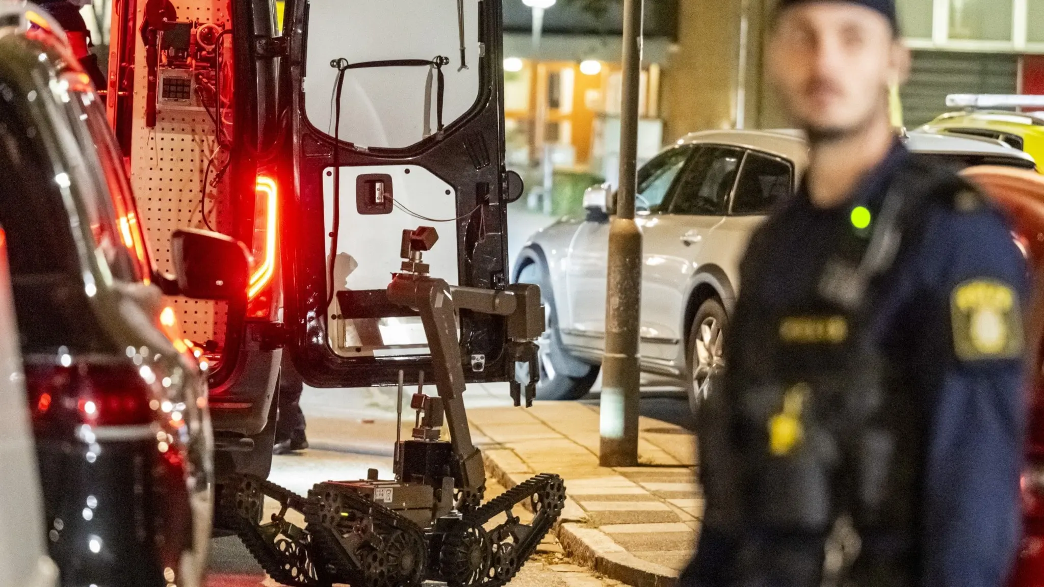  Polis i förgrunden och en bombrobot. 