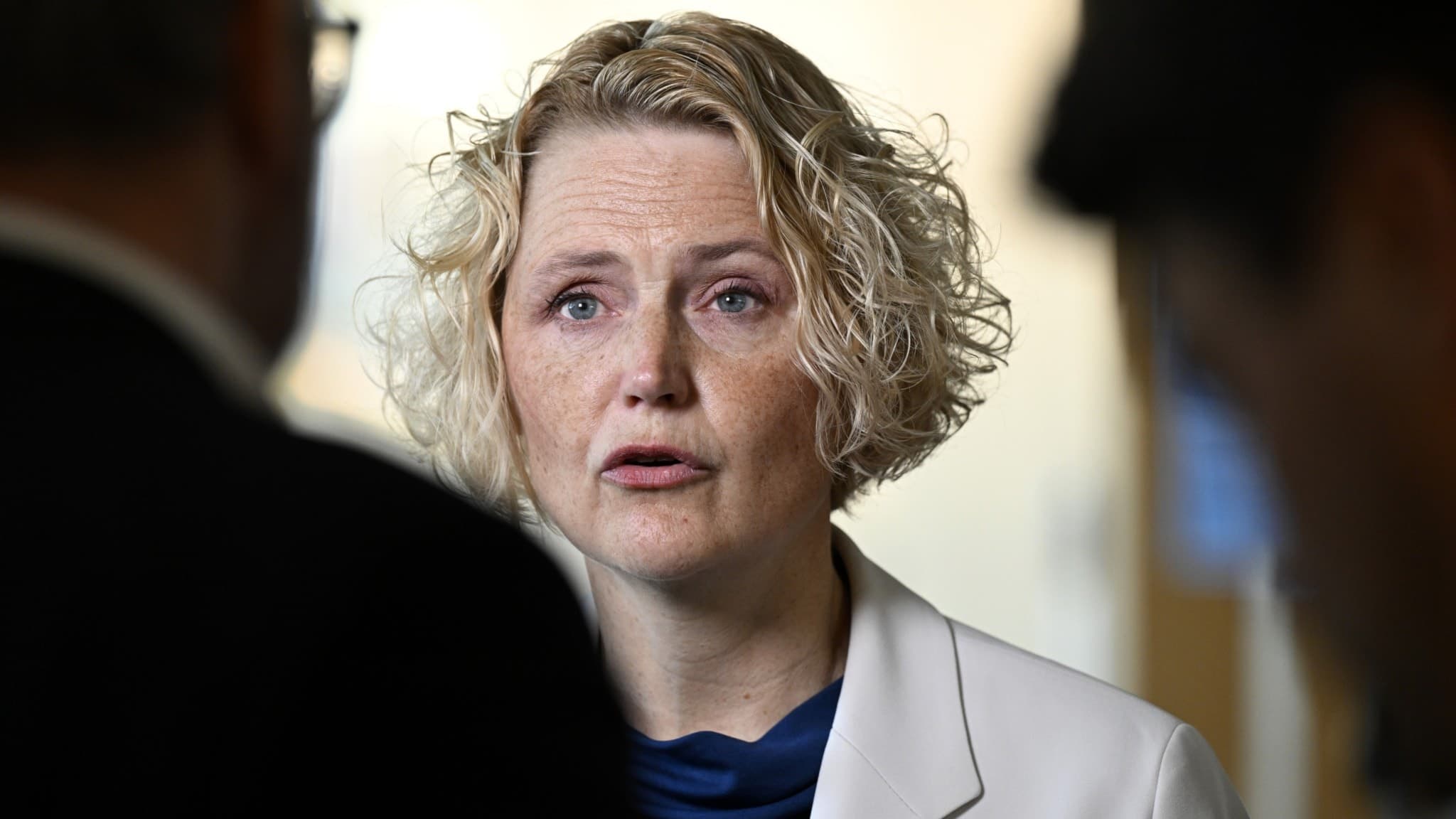 Centerpartiets partiledare Anna-Karin Hatt står i vit kavaj och blå topp under en presskonferens i Stockholm där hon kommenterar sin avgång som partiledare.