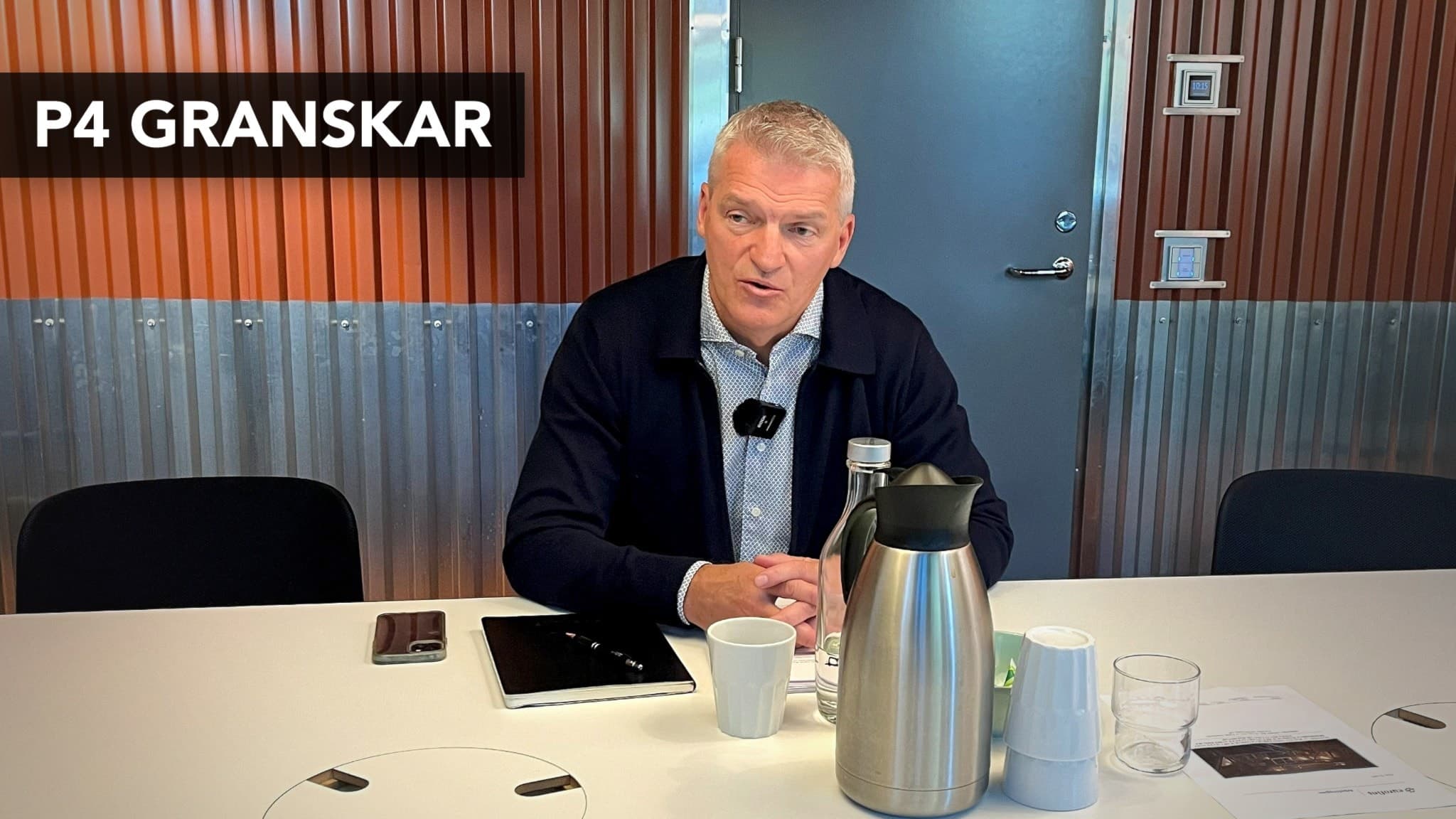 Roland Karlsson, produktionschef på Stena Recycling i Halmstad, sitter vid ett konferensbord med kaffetermos och koppar framför sig. Bakgrunden är en vägg med metalliska och träfärgade paneler.